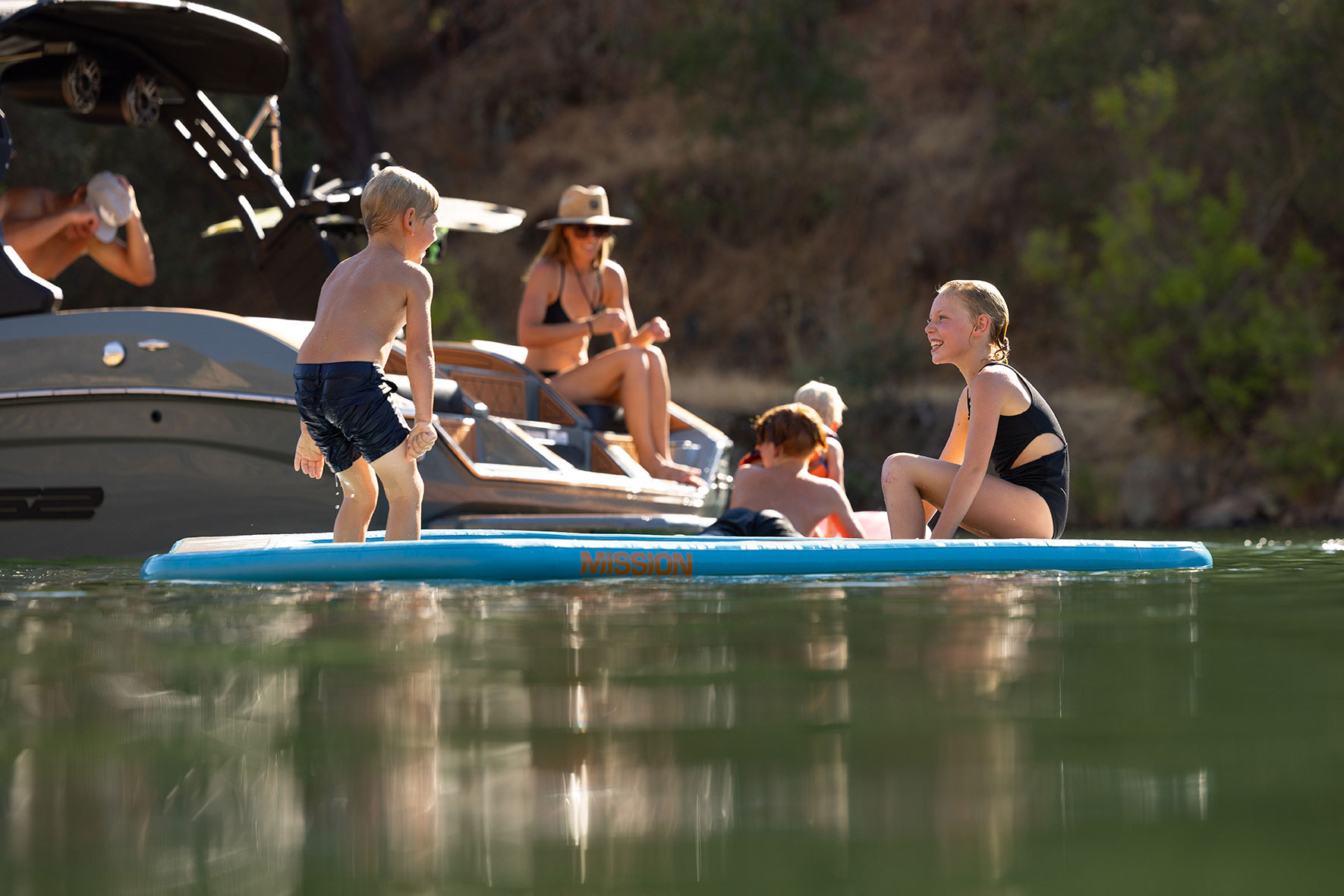 family fun behind the 21 alpha with kids playing in the water